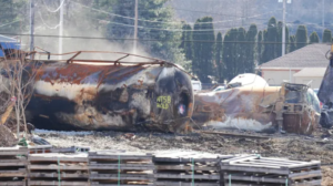 burnt railcar sitting on it's side marked NTSB Hold