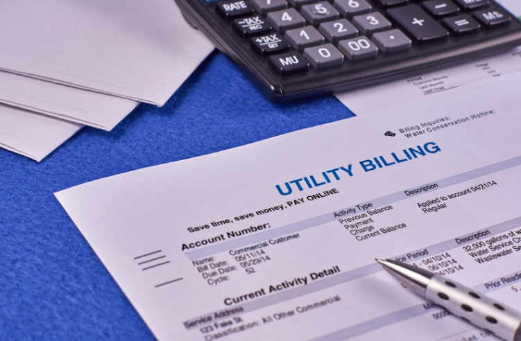 Photo of a utility bill with a calculator and pen. 